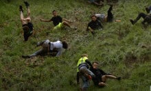 People falling down a steep hill are frozen in various stages of tumbling over.