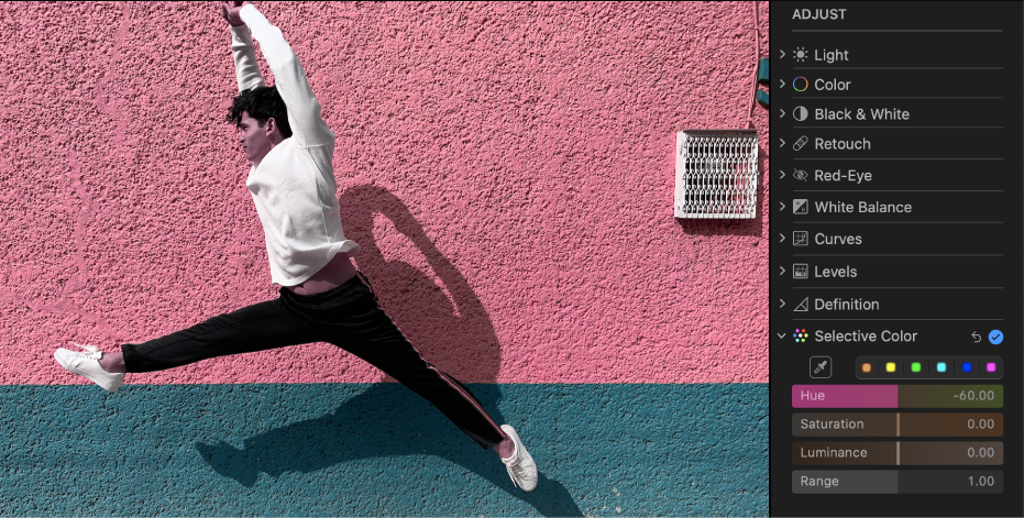 Una foto después de aplicarle un ajuste de color selectivo, que muestra la pared del fondo que ha pasado a ser de color rosa.