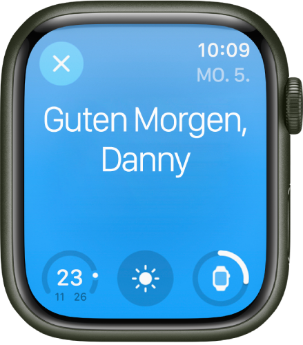 Apple Watch mit der Begrüßung beim Aufwachen. Oben wird „Guten Morgen“ angezeigt. Darunter stehen Informationen zum Batterieladezustand.