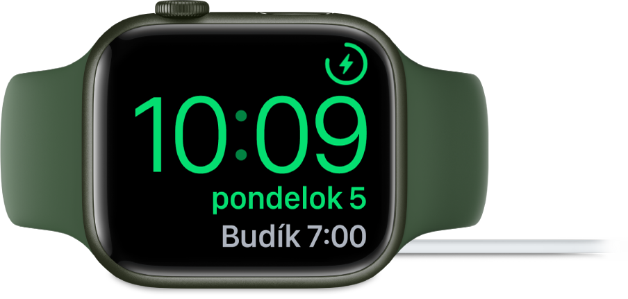 Hodinky Apple Watch otočené nabok a pripojené k nabíjačke. Na obrazovke je zobrazený symbol nabíjania v pravom hornom rohu, pod ním je aktuálny čas a nižšie je čas nasledovného budíka.