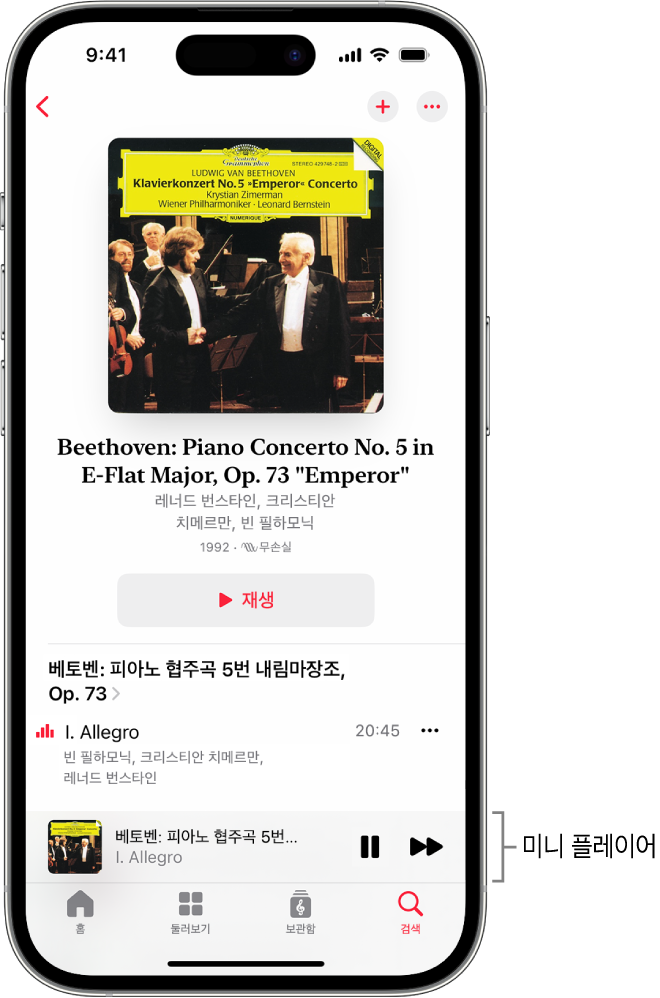 iPhone이 Apple Music Classical의 미니 플레이어를 표시함. 화면 상단에는 앨범 표지, 작품 이름 및 재생 버튼이 있음. 화면 하단 부근에 미니 플레이어가 있음. 미니 플레이어 아래에는 홈, 둘러보기, 보관함 및 검색 버튼이 있음.