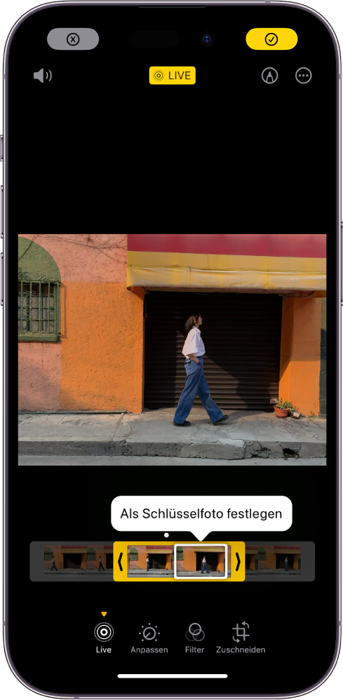 Bildschirm mit einem Live Photo in der Bildschirmmitte. Unter dem Foto ist die Bildansicht mit der aktiven Taste „Als Schlüsselfoto festlegen“ zu sehen. Mit den Pfeilen an beiden Enden der Bildansicht kann das Live Photo gekürzt werden. Unten auf dem Bildschirms befinden sich die Tasten „Live“, „Anpassen“, „Filter“ und „Zuschneiden“. Die Taste „Live“ ist ausgewählt. Die Taste „Abbrechen“ befindet sich oben links und die Taste „Fertig“ oben rechts auf dem Bildschirm. Außerdem befinden sich oben auf dem Bildschirm von links nach rechts die Tasten „Stumm“, „Live“, „Markieren“ und „Plug-ins“.