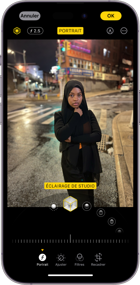 L’écran Modifier d’une photo en mode Portrait. La photo se trouve au centre de l’écran et les options de l’effet « Éclairage de portrait » sont sous la photo. L’option « Éclairage de studio » est sélectionnée. En dessous, un curseur permet de régler le niveau de l’effet. En bas de l’écran, de gauche à droite, se trouvent les boutons Portrait, Ajuster, Filtres et Recadrer. Le bouton Portrait est sélectionné.