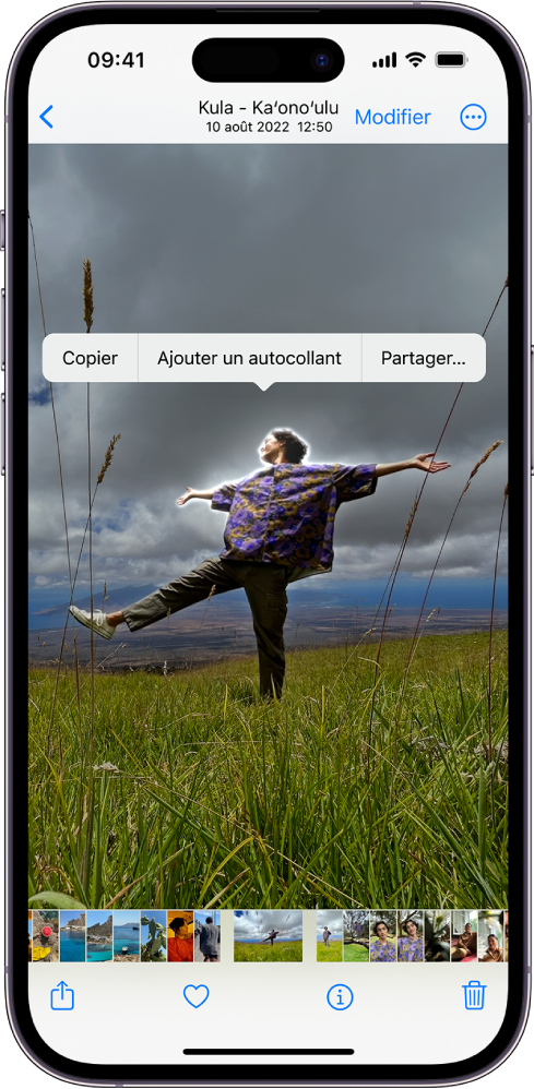 L’app Photos est ouverte sur la photo d’une personne. La personne est sélectionnée, et l’option « Ajouter des autocollants » est disponible dans le menu situé au-dessus.