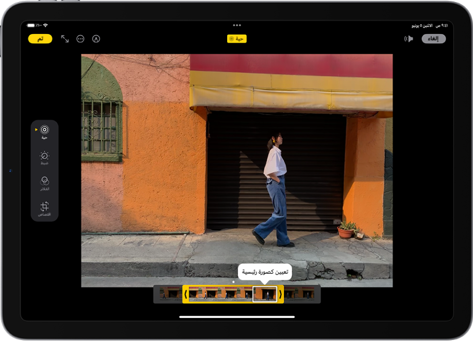 تظهر صورة حية في منتصف شاشة تعديل في تطبيق الصور. يظهر عارض إطار الفيديو عبر الجزء السفلي من الفيديو ويظهر تخطيط أصفر حول الأُطر المحددة لتضمينها في الصورة الحية المعدّلة؛ إطار فردي محدد لإنشاء صورة رئيسية. تظهر أدوات التعديل على الجانب الأيمن من الشاشة: من أعلى إلى أسفل: صورة حية وضبط والفلاتر واقتصاص. مع تحديد صورة حية.