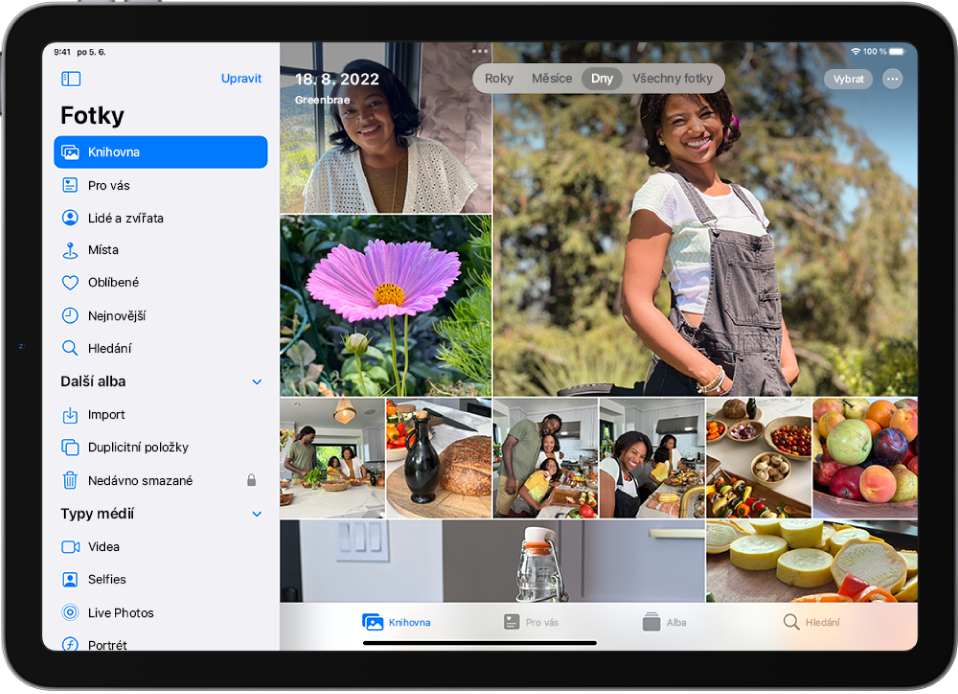 Na levé straně obrazovky je v aplikaci Fotky vidět boční panel s vybranou volbou Knihovna. Zbytek obrazovky zabírá knihovna fotek v zobrazení Všechny fotky. V knihovně fotek je vlevo nahoře uvedené datum a místo pořízení fotek. Nahoře uprostřed jsou vidět volby pro zobrazení fotek v uspořádání Roky, Měsíce, Dny a Všechny fotky. Uspořádání Dny je vybrané. V pravém horním rohu obrazovky jsou umístěná tlačítka Vybrat a Více.