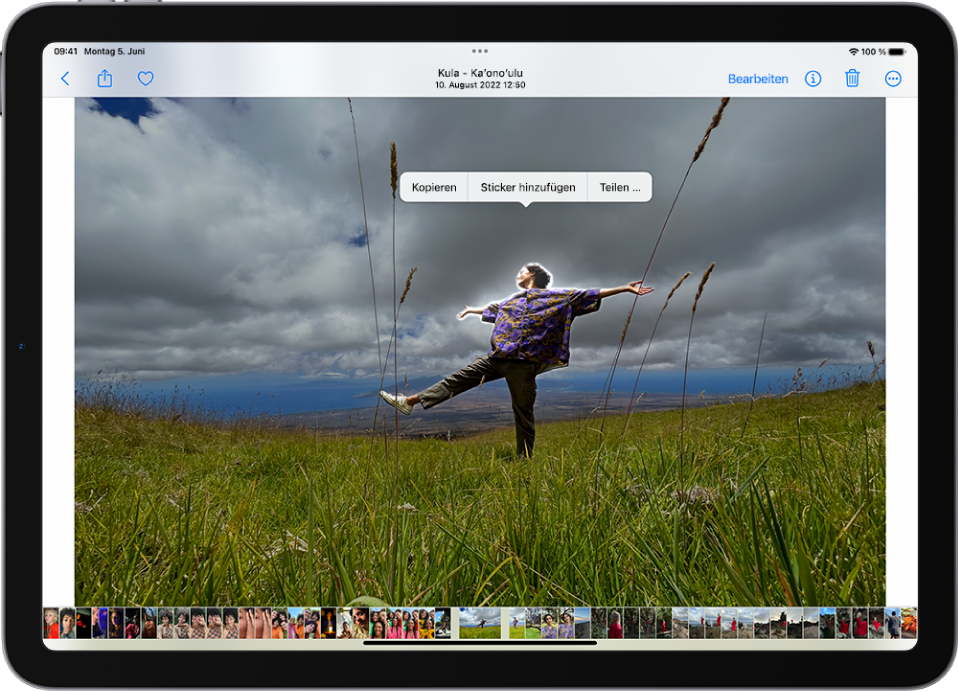 In der App „Fotos“ ist das Foto einer Person geöffnet. Die Person ist ausgewählt und die Option „Sticker hinzufügen“ ist in dem Menü darüber verfügbar.