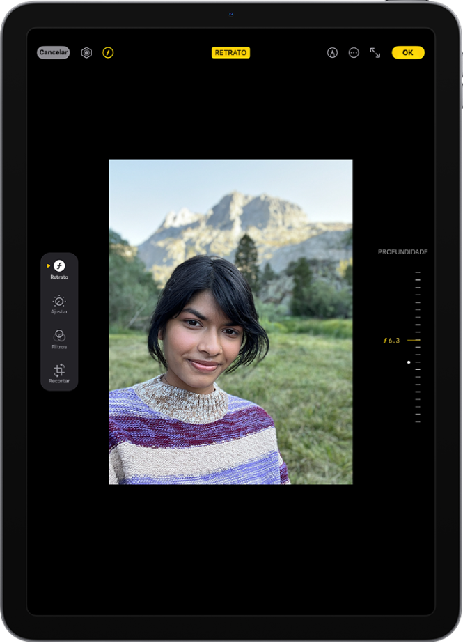 O ecrã Editar de uma fotografia do modo Retrato. Uma fotografia de retrato ao centro do ecrã. No lado direito do ecrã está um nivelador para ajustar a definição Ajuste de profundidade. No lado esquerdo do ecrã encontram‑se os botões Retrato, Ajustar, Filtros e Recortar. O botão “Retrato” está selecionado.
