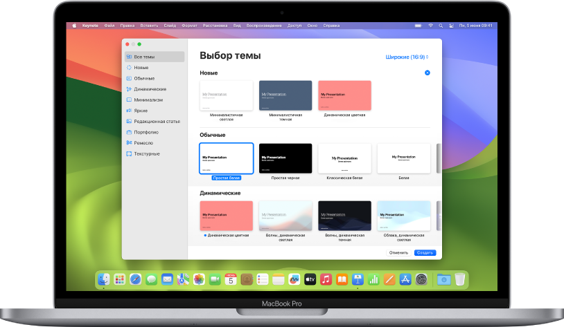 MacBook Pro с открытым окном выбора темы Keynote. Слева выбрана категория «Все темы», справа отображаются готовые темы, упорядоченные в ряды по категориям. Всплывающее меню «Язык и регион» находится в левом нижнем углу, а всплывающее меню «Стандартный» или «Широкий» — в правом верхнем углу.