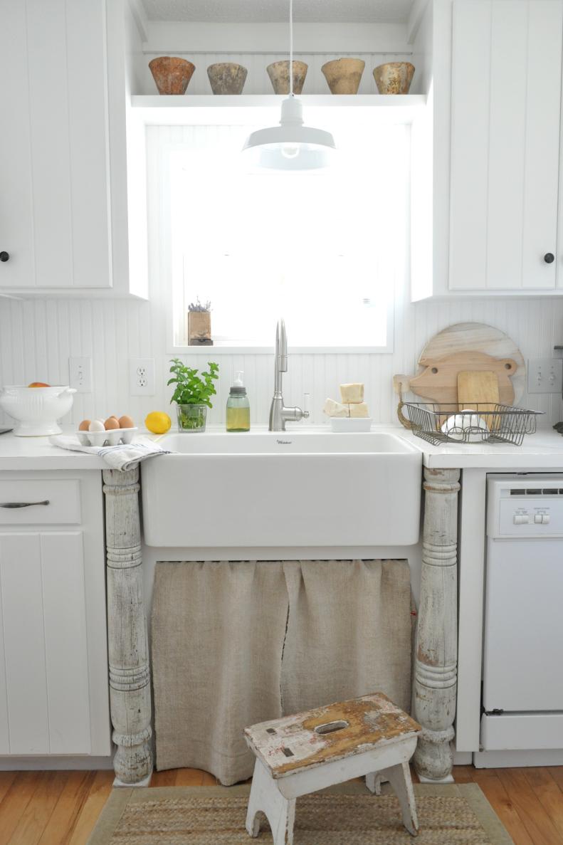 Whitehaus farm sink and grainsack curtain...vintage columns, white countertops