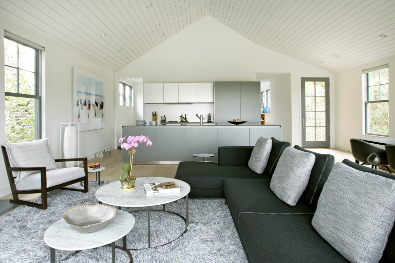 White Living Room With Gray Sectional, Round Coffee Table