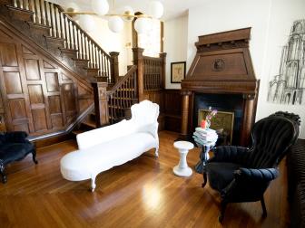 Brown Foyer with Black Armchairs, a White Chaise and Brown Fireplace 