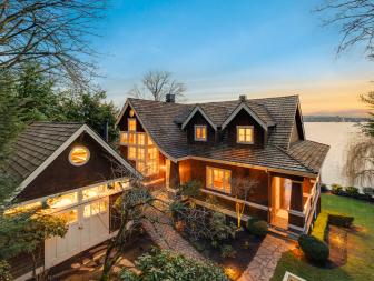 Exterior View With Light Seeping Through The Well-Lit Home At Dusk 