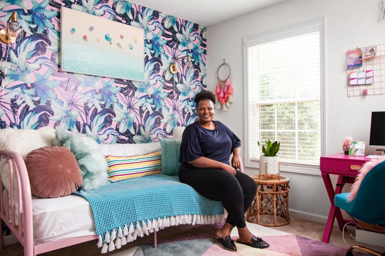Woman Smiles To Camera Seated on Guest Room Daybed, Colorful Wallpaper