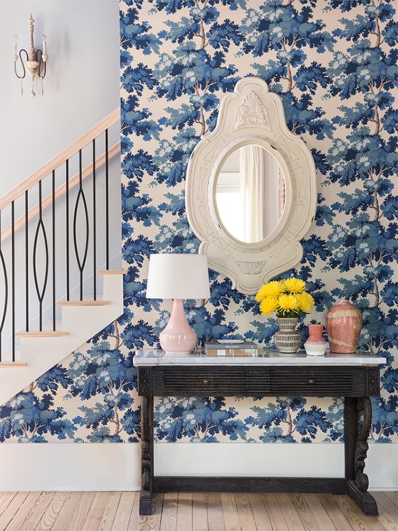 With its leafy wallpaper by Sandberg, the entryway is like an enchanted forest. The console is from Anthropologie, and the heirloom-like mirror is from HomeGoods.