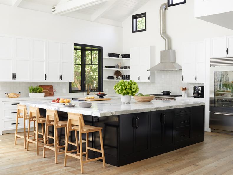 With a crisp palette and a large marble-top island already in place, it felt made for Christina and her family. She replaced most of the open shelves with upper cabinets. “I have more kids’ cups I’d rather hide away than cute knickknacks to display,” she says. The square tile backsplash is by Clé and the oak counter stools are from Industry West.