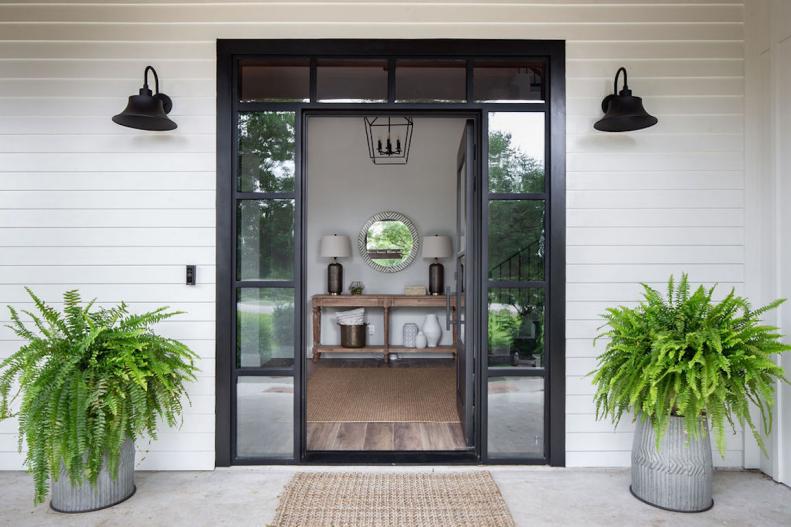 Modern Farmhouse Entry With White Siding And Metal Glass Front Door