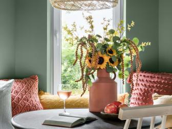 Mixing faux and organic floral for a seasonal spruce-up offers the best of both worlds. This arrangement is made with live sunflowers and silver dollar eucalyptus, two species that will live for weeks in vessels with proper care. To add an autumnal touch, faux branches with yellow petals and coral buds were added.