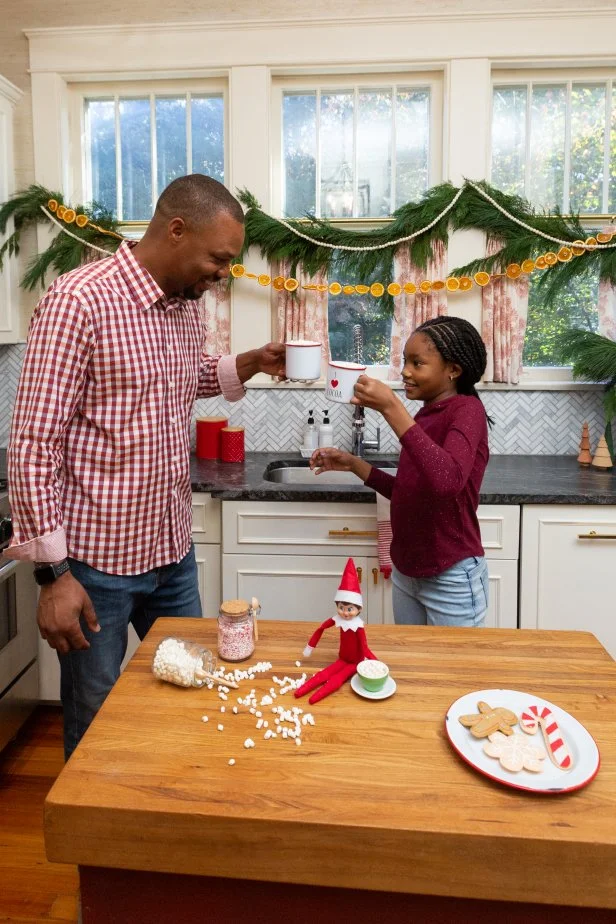 Elf on the Shelf ® is a game played at Christmastime where a Scout Elf visits from the North Pole to see who made Santa's nice list. Each night, after the kids are in bed, parents move the elf into different poses. This elf made a small mess setting up a hot chocolate station, but the family hot chocolate night can still go on.