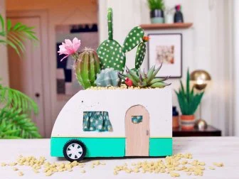 Concrete planter made to look like vintage camper filled with cacti