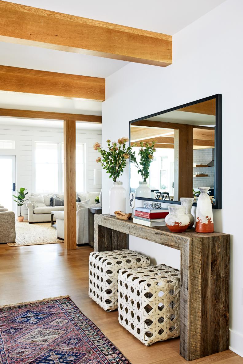 Bright Foyer Features Exposed Wood Beams and a Modern Mirror