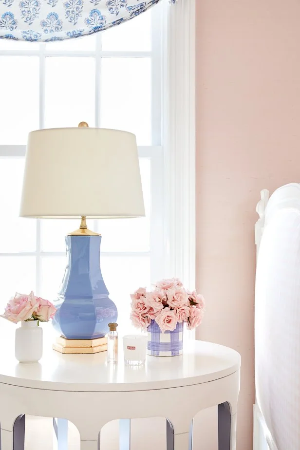 Nosegays of roses bring a touch of romance to this bedside table tableau.