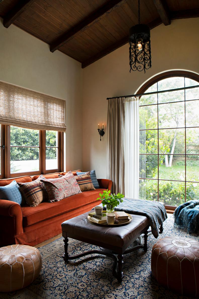 Mediterranean style living space with bold sofa and leather ottomans. 