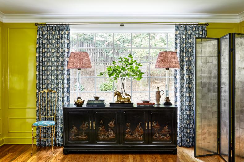 Bright green living room with large window and inlaid-wood cabinet.