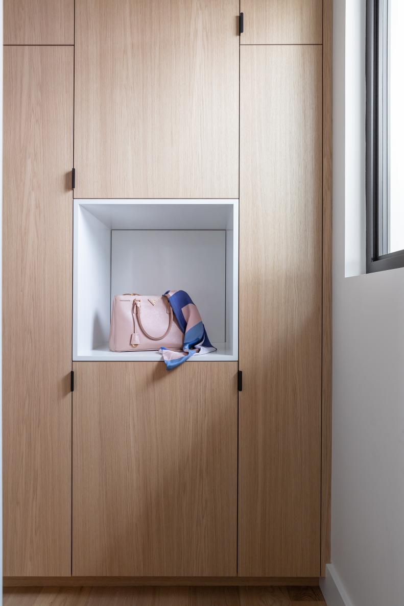 White oak cabinets with asymmetrical doors and a white cubby