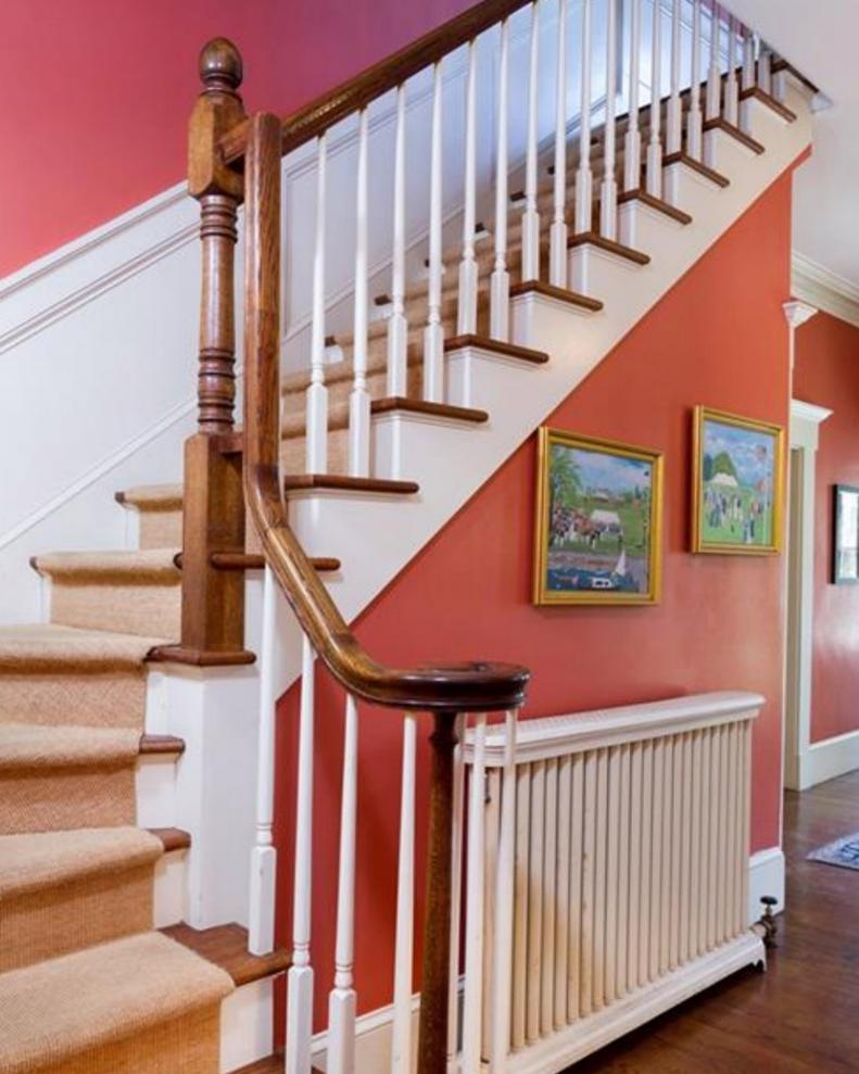 Bold Red Walls Leading Up Staircase in Traditional Foyer