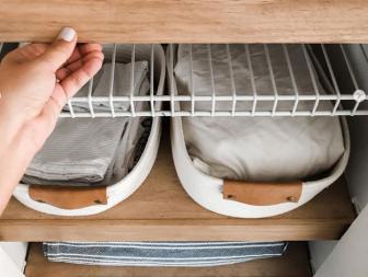 Hand lifting up wood shelf cover to reveal wire shelf underneath