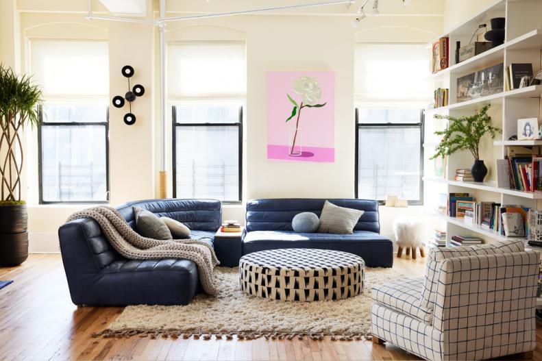 A photo of a cream-colored living room with blue sectional.