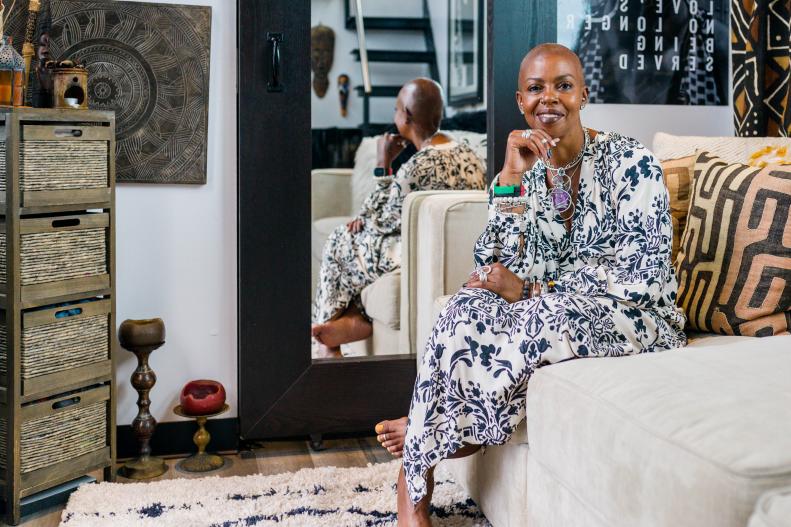 Jewel Pearson poses on a sofa in her tiny home living room