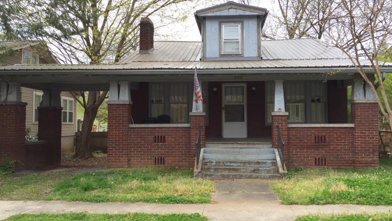 Dated Craftsmans style home with tin roof, old windows and steps