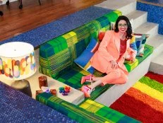 Woman in peach suit on green and yellow banquette. 