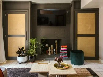 A photo of a fireplace between two black and brown doors.