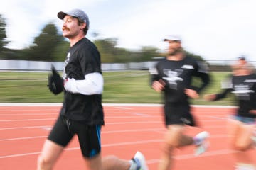 a man running on a track with a blurry background