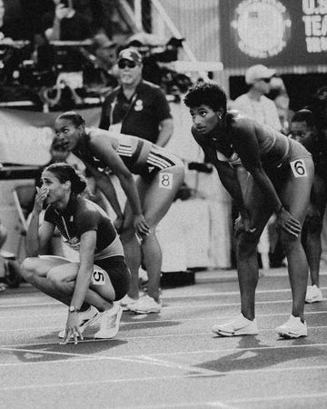 three woman track athletes look up and wait for results after a race
