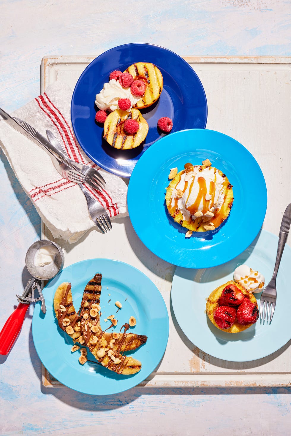 grilled fruit desserts and ice cream served on blue plates in various shades