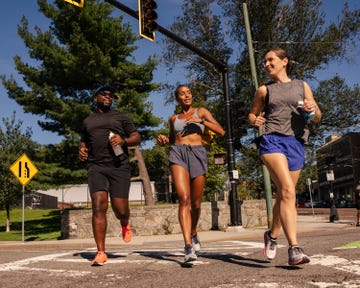 three runners jogging across a crosswalk