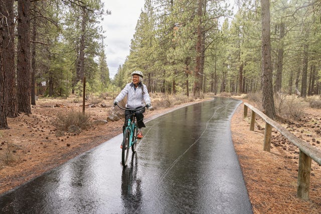 biking in the rain active mixed race senior woman on relaxing bike ride