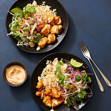 fish taco bowls with rice and cabbage on a black plate