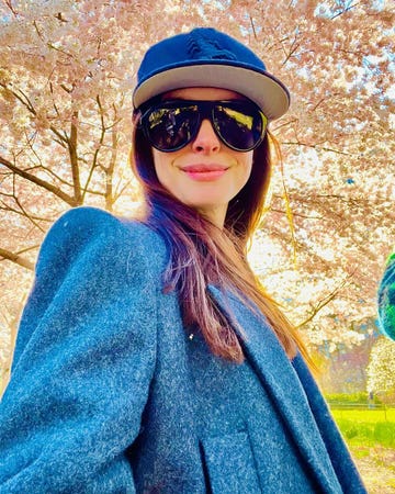 anne hathaway wearing a blue scorpion baseball cap