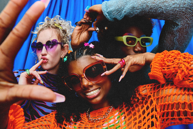 a group of people wearing sunglasses and holding their hands up