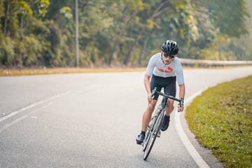 asian chinese professional cyclist athlete sportsman sprinting cycling in rural area