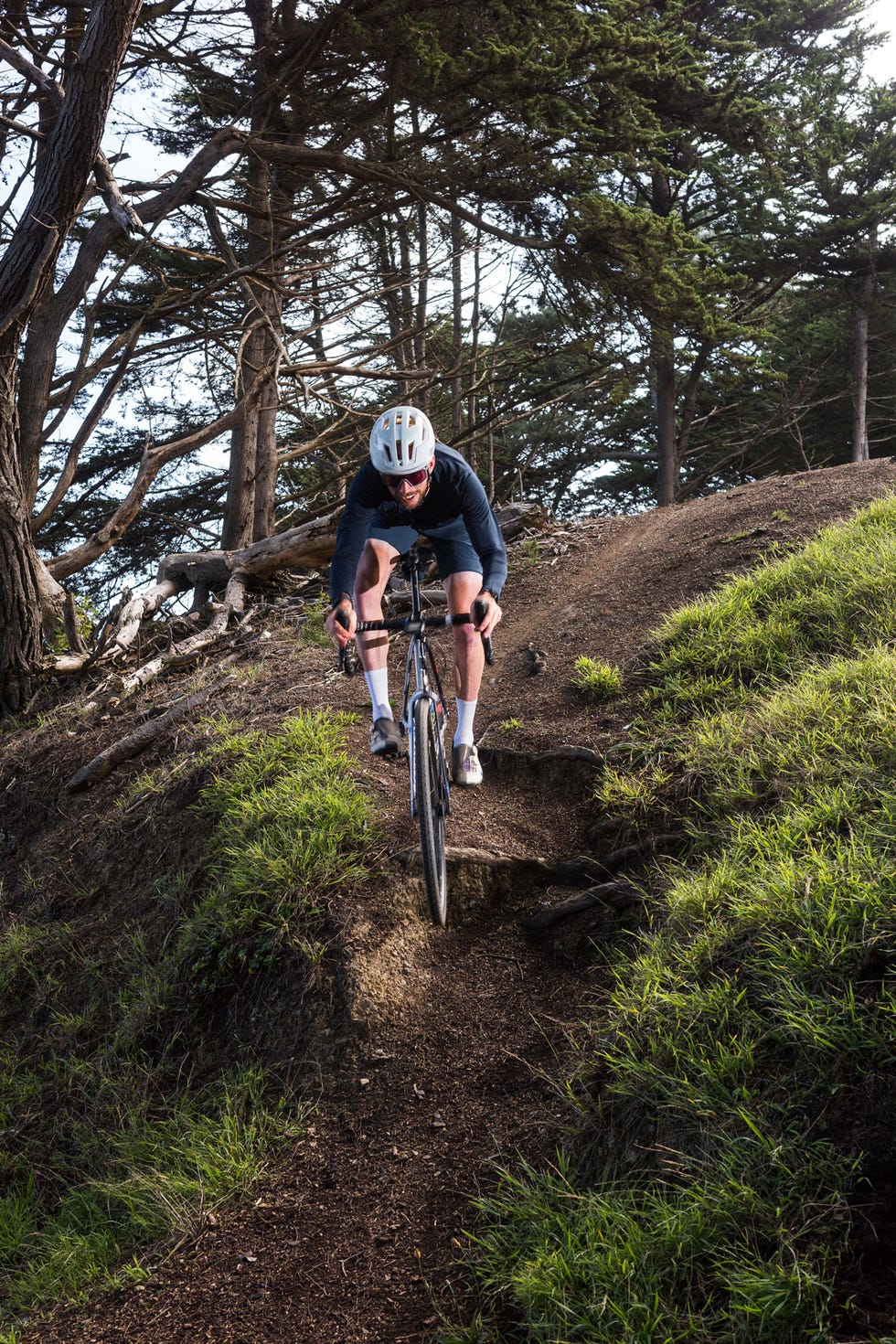 a person riding a bike on a trail in the woods