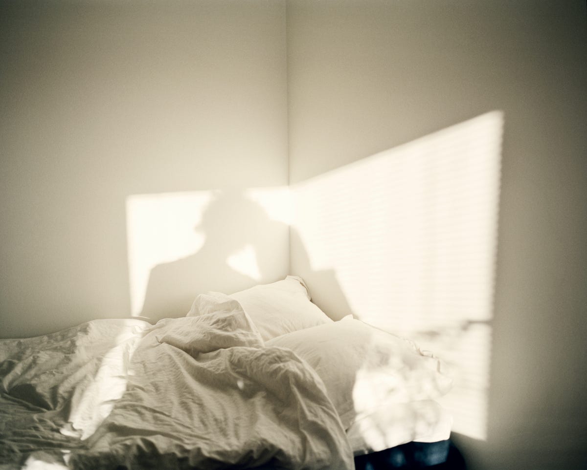 a person stands in front of a bed