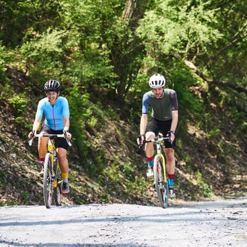 two cyclists riding up a gravel climb