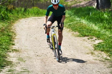 a man riding a bicycle on a dirt road