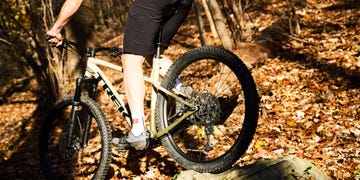 a person riding a bike on a trail in the woods